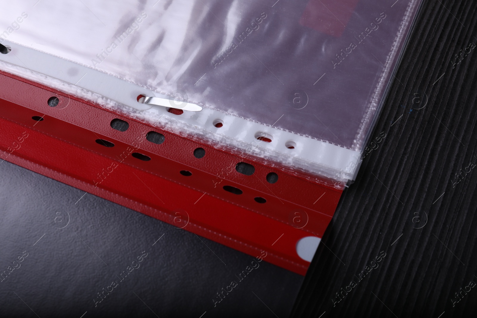 Photo of File folder with punched pockets on black wooden table, above view