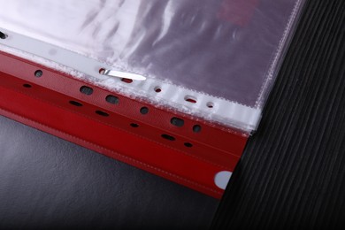 File folder with punched pockets on black wooden table, above view