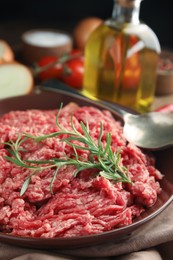 Fresh minced meat with rosemary on table, closeup