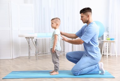 Orthopedist examining child's back in clinic. Scoliosis treatment