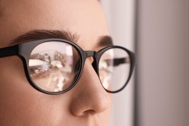 Woman wearing glasses on blurred background, closeup