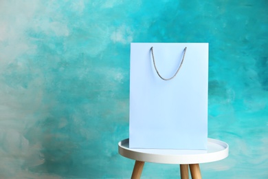 Photo of Mockup of paper shopping bag on table against color background