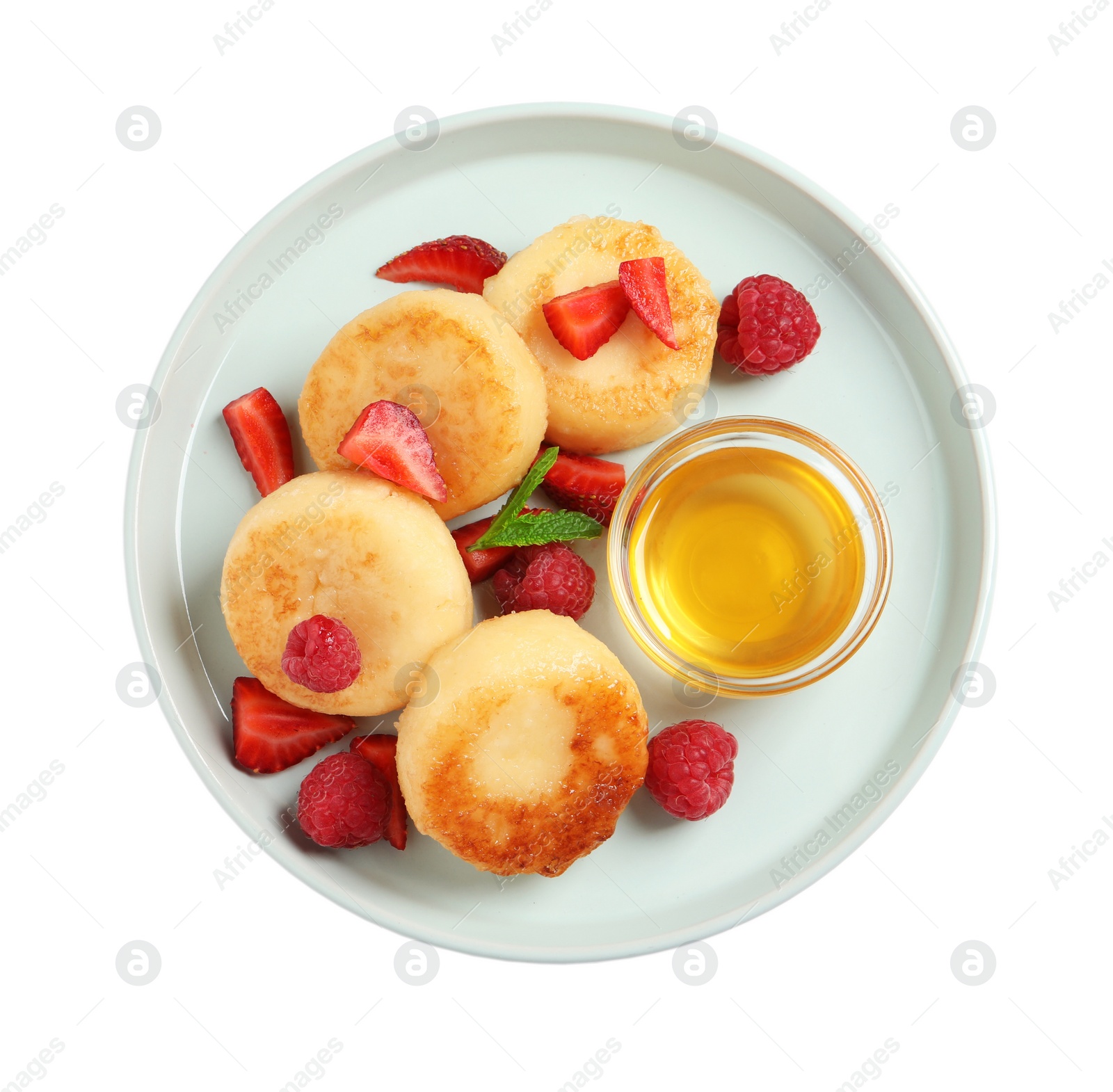 Photo of Delicious cottage cheese pancakes with fresh berries and honey on white background, top view