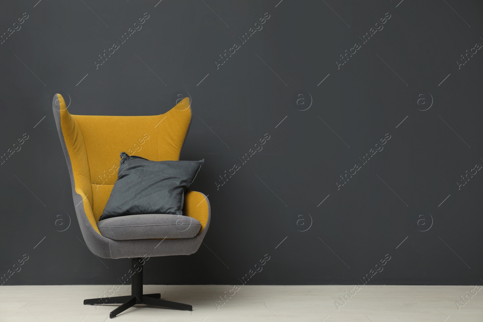 Photo of Stylish room interior with comfortable armchair and floor lamp near black wall. Space for text