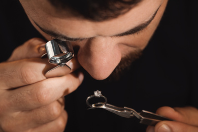 Photo of Professional jeweler working with ring, closeup view