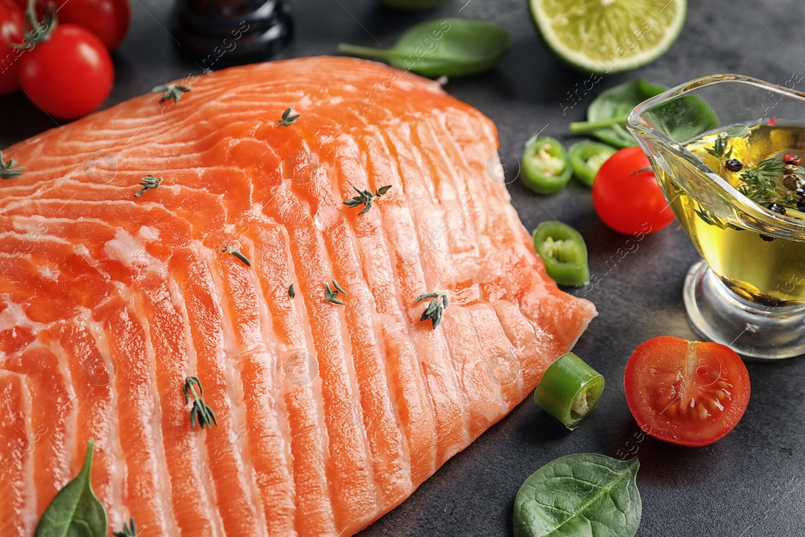 Photo of Raw salmon fillet and ingredients for marinade on table