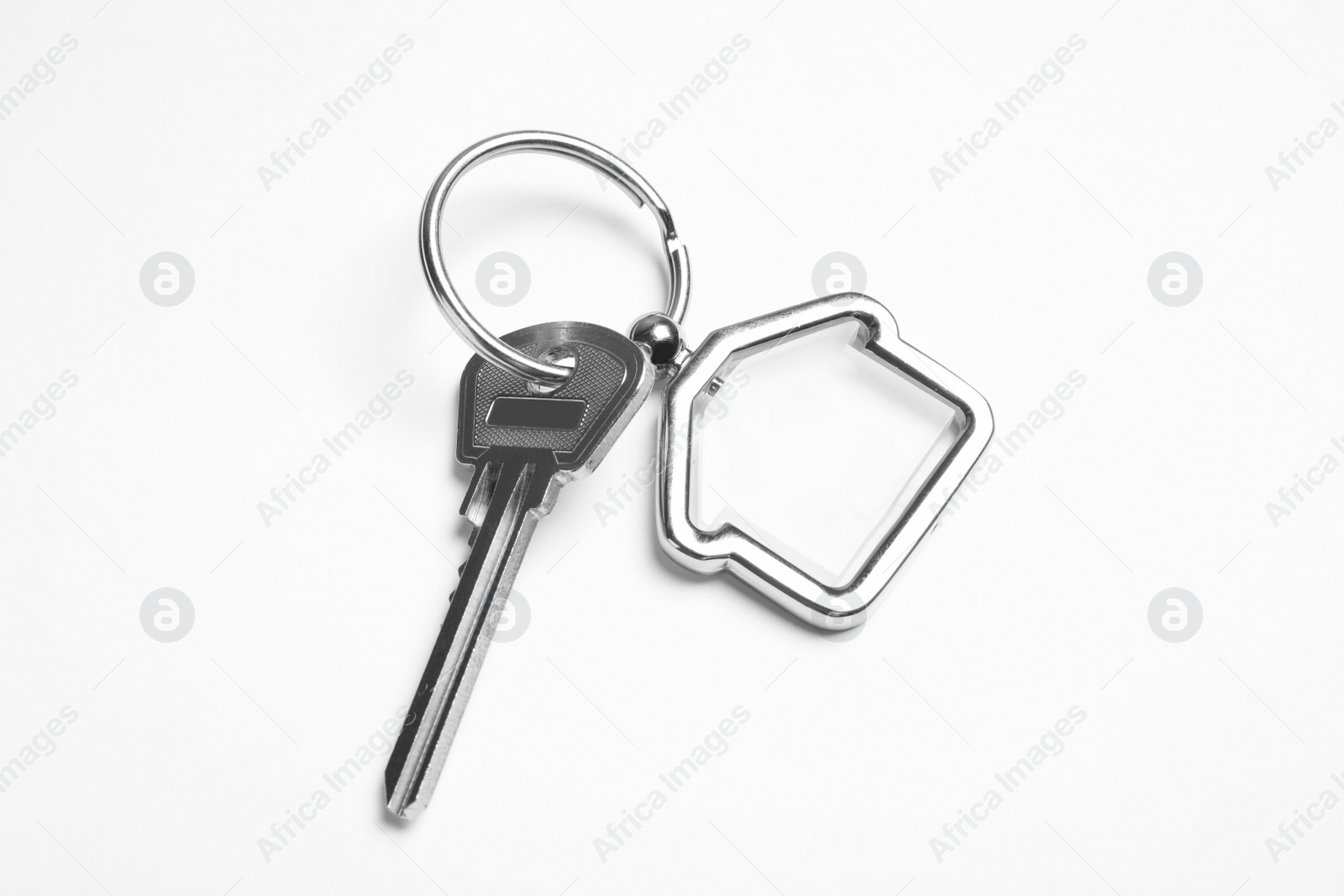 Photo of House key with trinket on white background