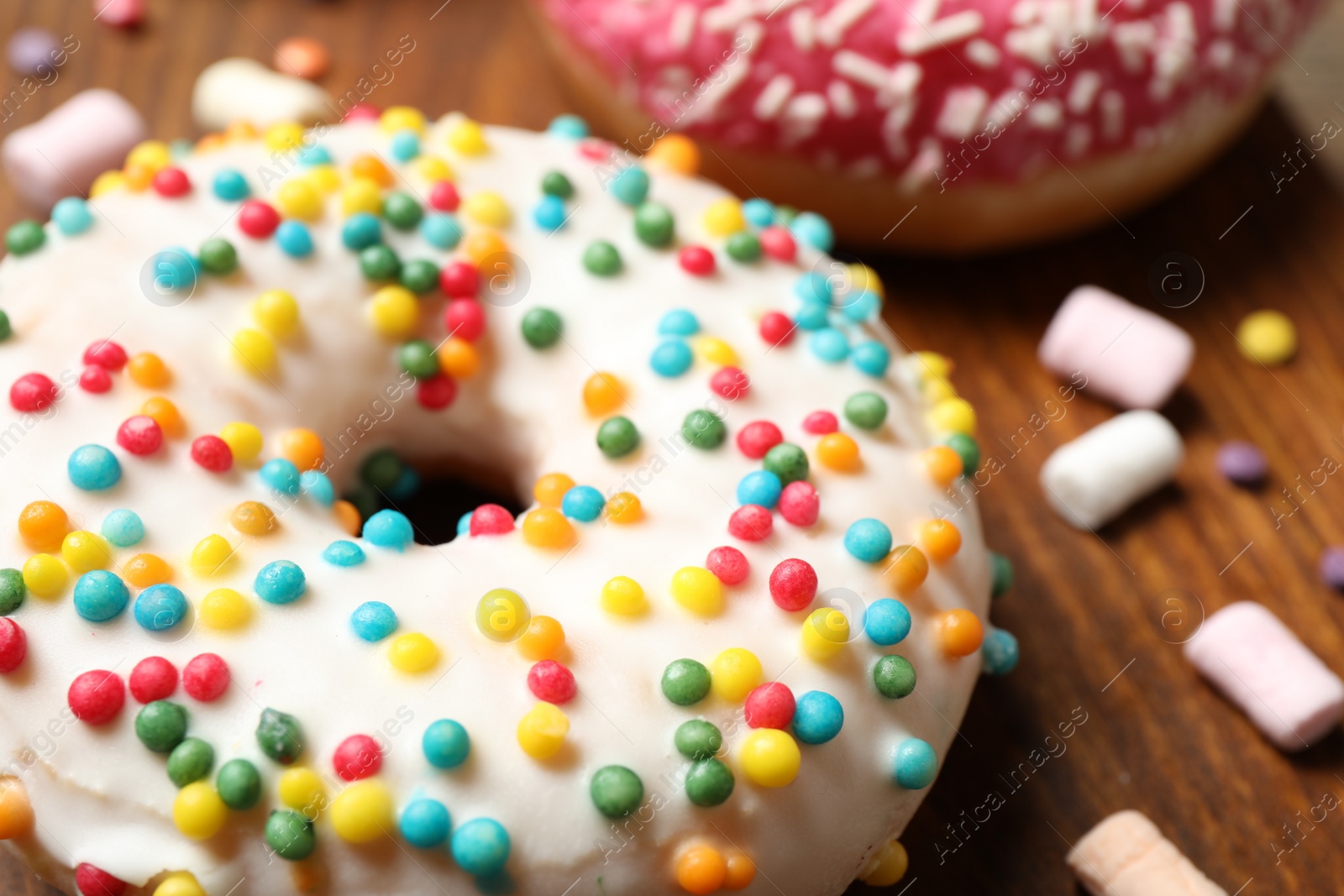 Photo of Yummy donut with sprinkles on board, closeup