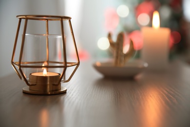 Burning candle in elegant holder on table