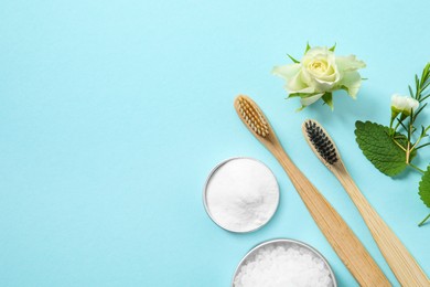 Flat lay composition with toothbrushes and herbs on turquoise background. Space for text