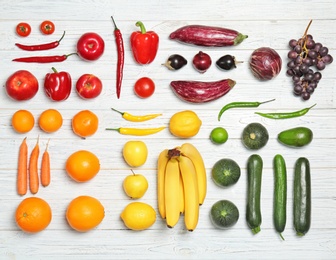 Photo of Rainbow composition with fresh vegetables and fruits on wooden background, flat lay