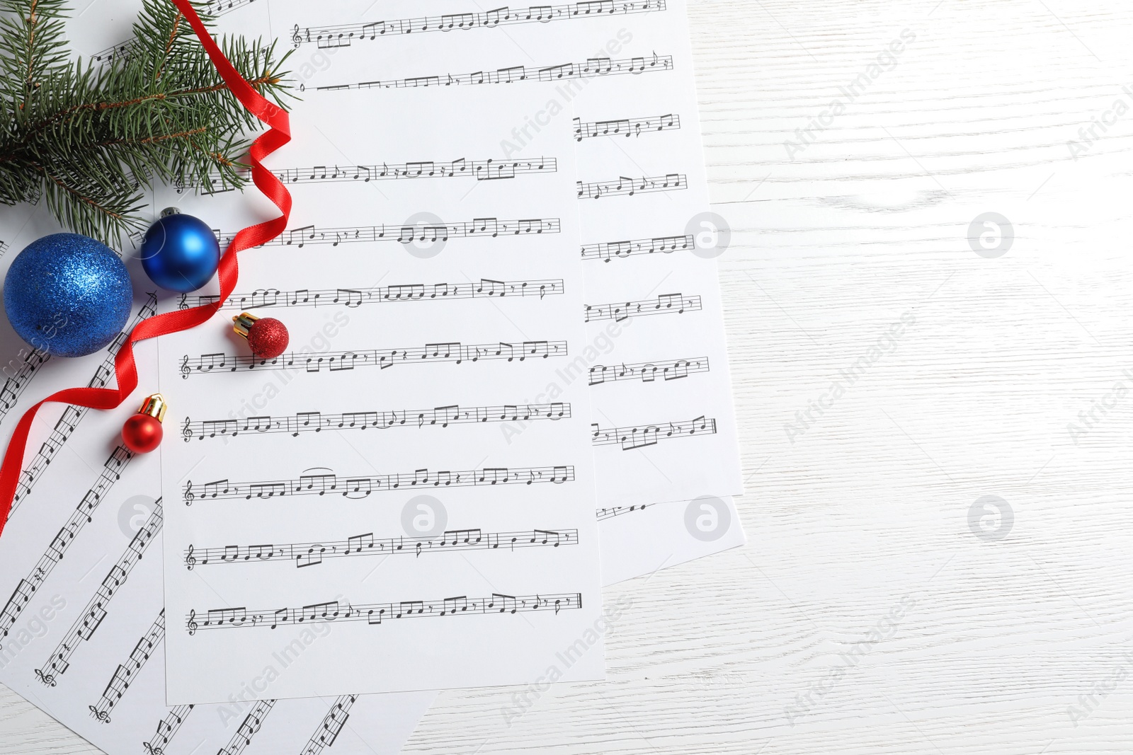 Photo of Flat lay composition with Christmas decorations and music sheets on wooden background