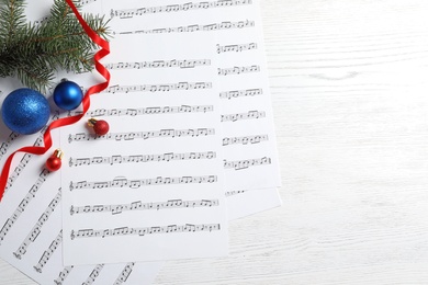 Photo of Flat lay composition with Christmas decorations and music sheets on wooden background