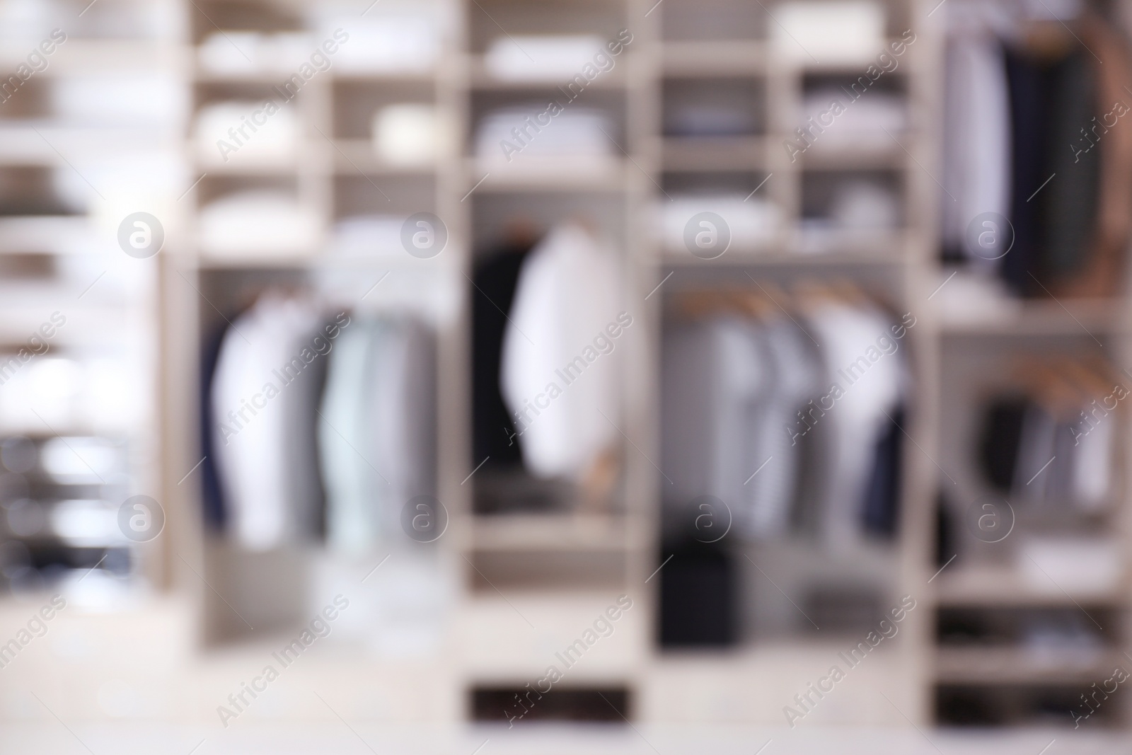 Photo of Blurred view of large wardrobe closet with clothes and home stuff