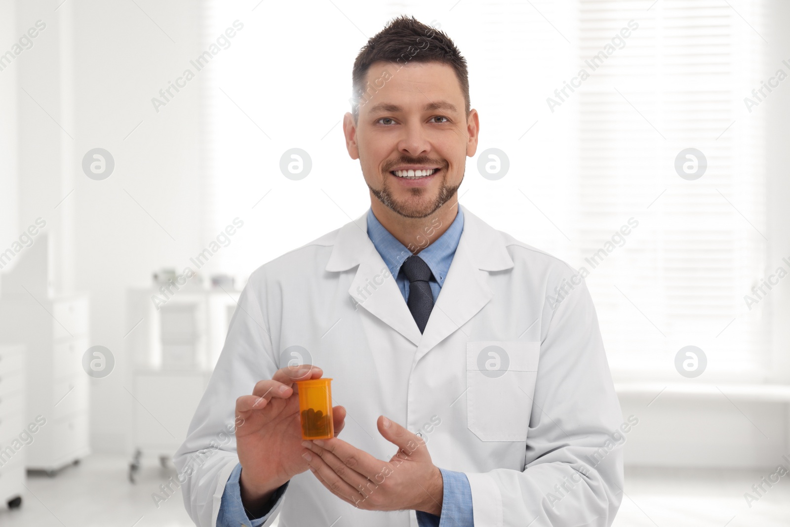 Photo of Portrait of professional pharmacist with pills in drugstore