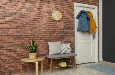 Photo of Hallway interior with stylish furniture, clothes and accessories