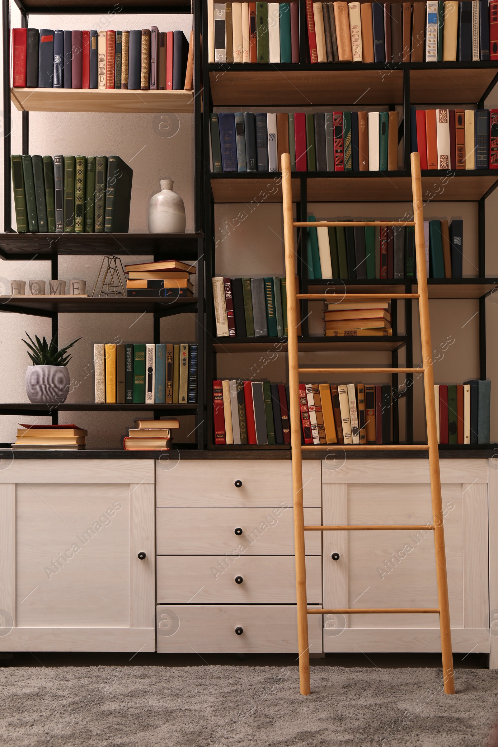 Photo of Home library interior with wooden ladder and collection of books on shelves