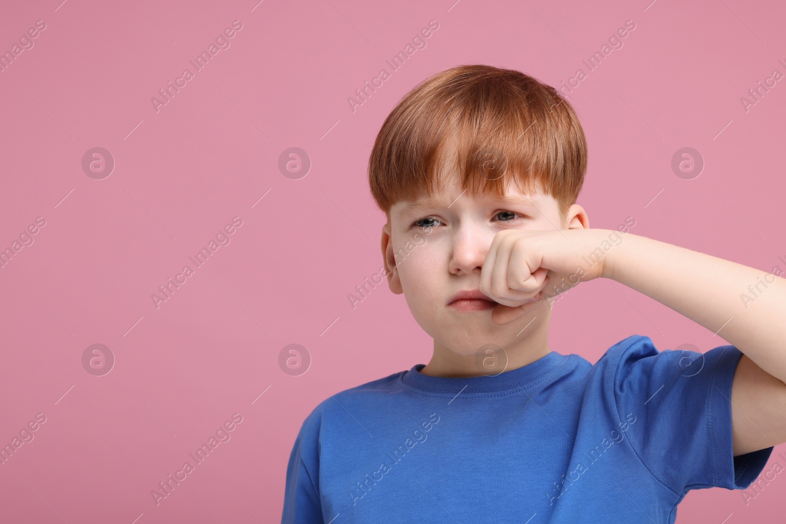 Photo of Portrait of sad little boy on pink background, space for text