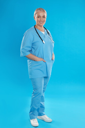 Photo of Portrait of mature doctor with stethoscope on blue background