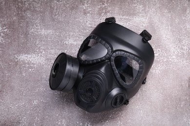 One gas mask on grey textured background, top view