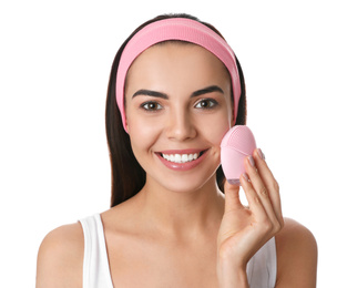 Young woman using facial cleansing brush on white background. Washing accessory