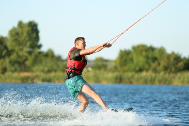 Photo of Man wakeboarding on river. Extreme water sport