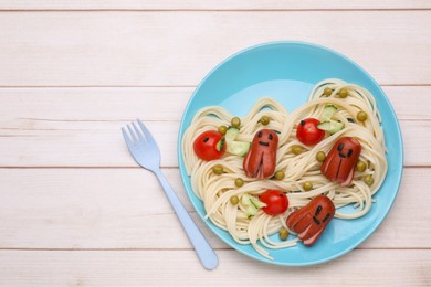 Photo of Creative serving for kids. Plate with cute octopuses madesausages, pasta and vegetables on white wooden table, flat lay. Space for text