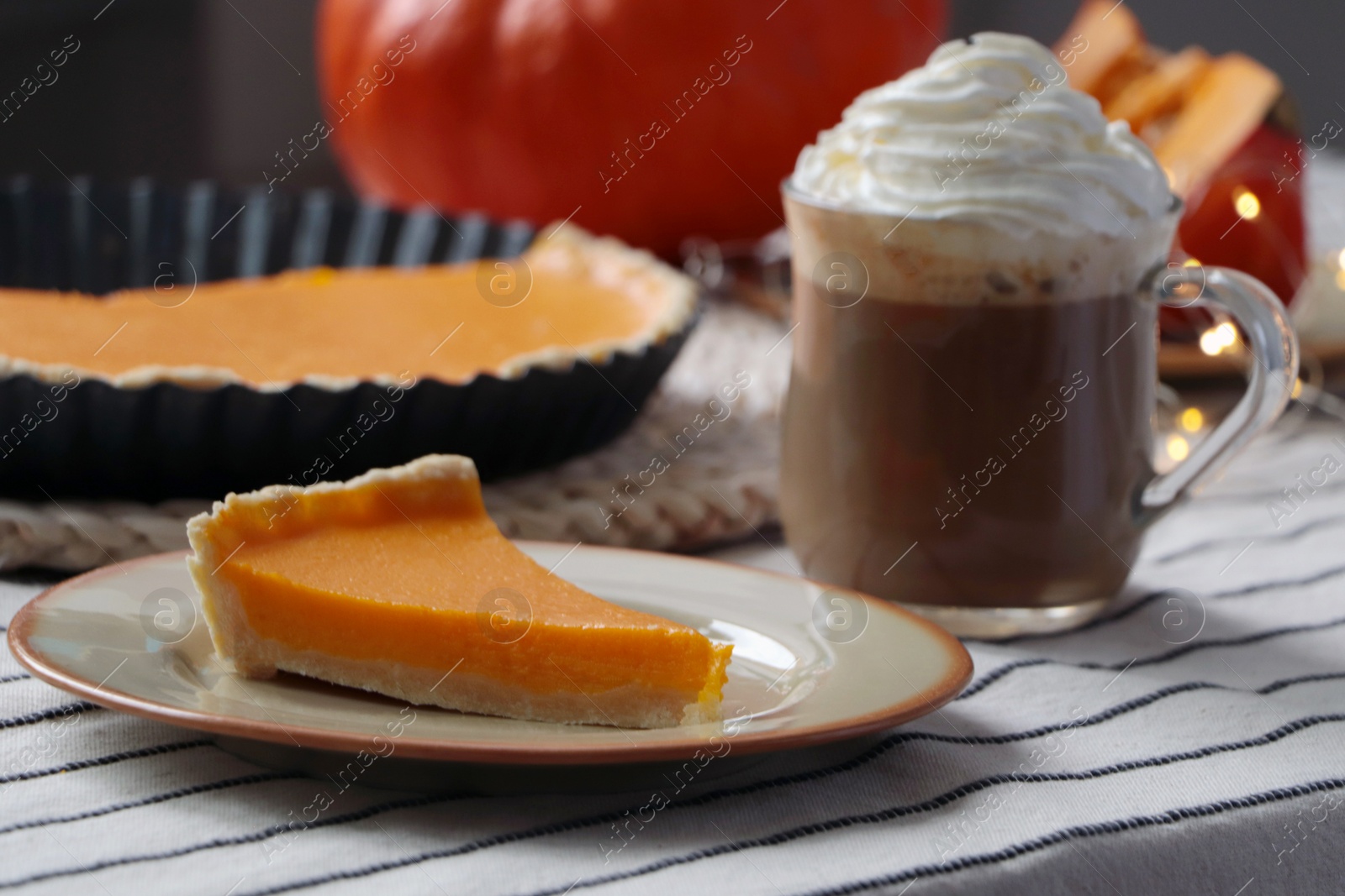 Photo of Fresh homemade pumpkin pie and cup of cocoa with whipped cream on table