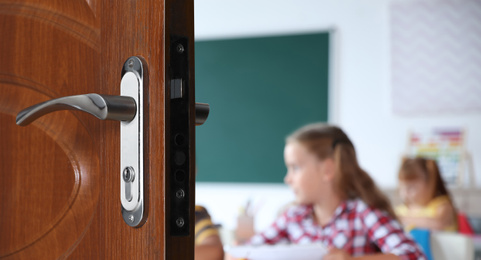 Image of Wooden door open into modern classroom with students, banner design
