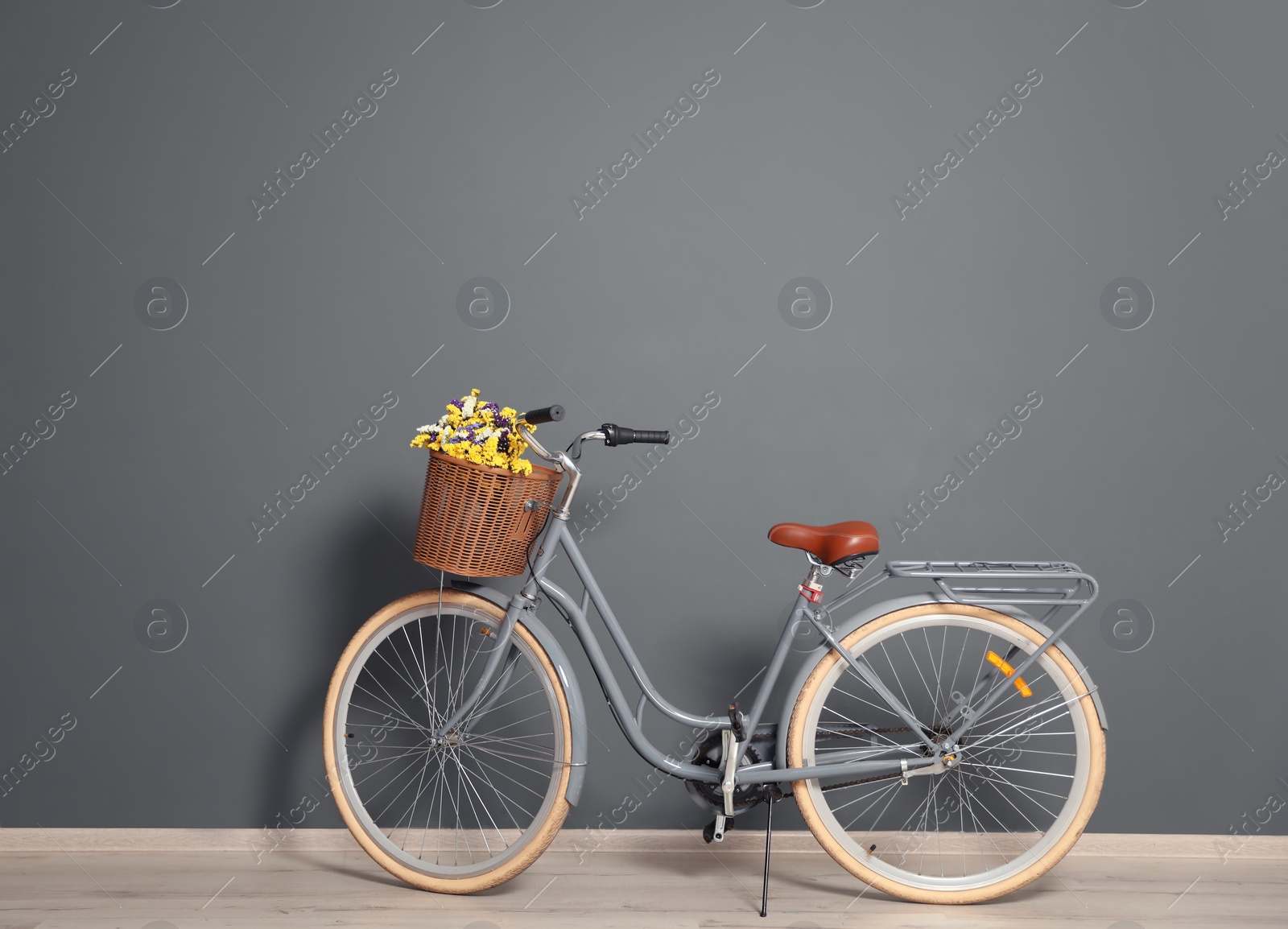 Photo of Retro bicycle with wicker basket near color wall