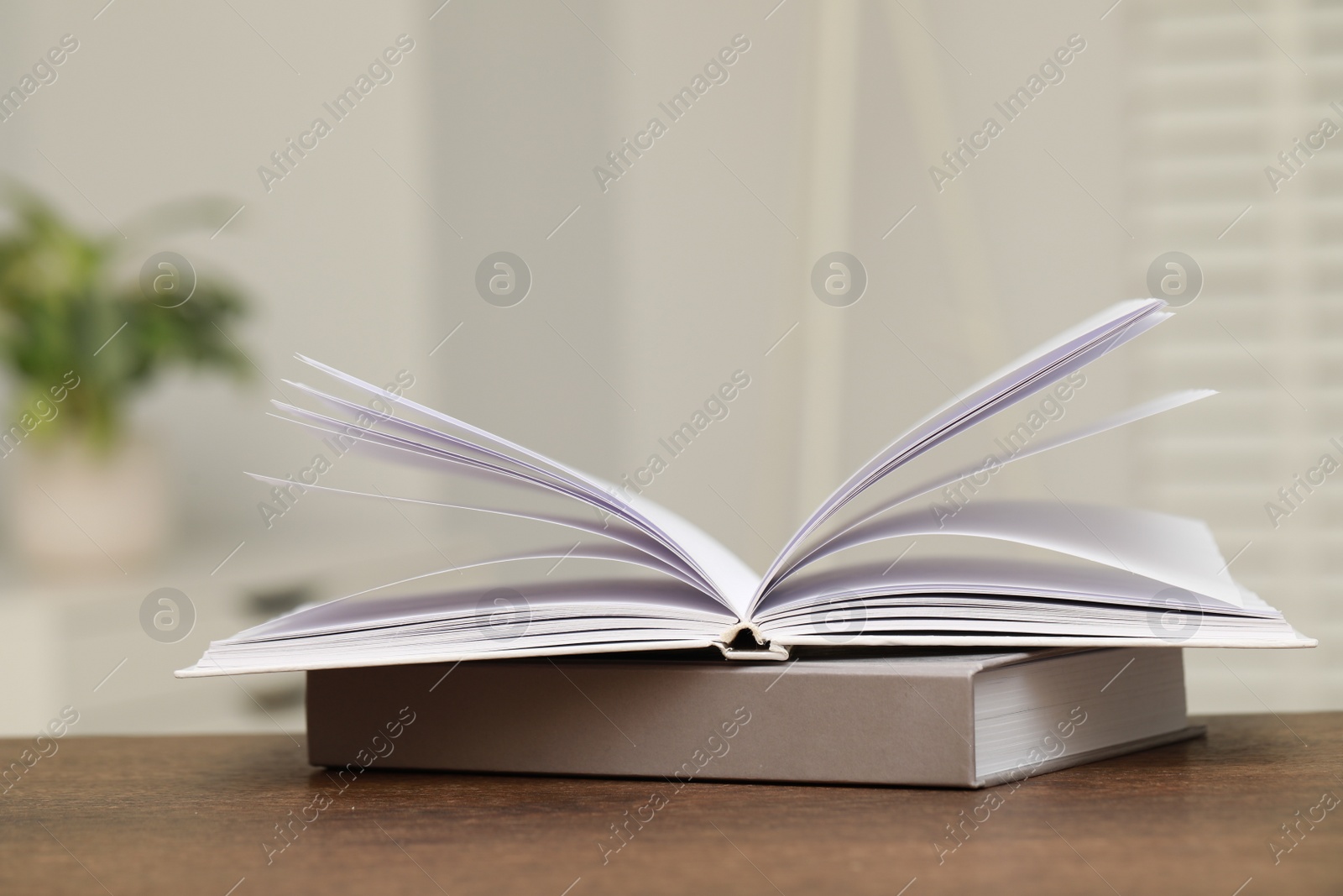 Photo of Stack of hardcover books on wooden table indoors