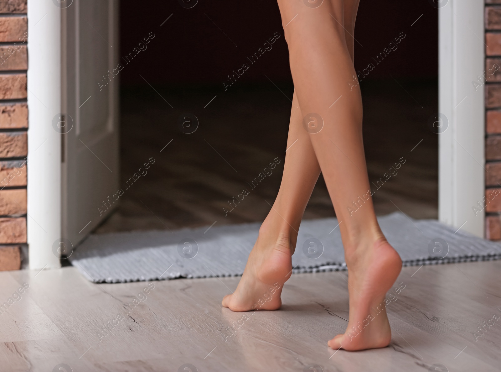 Photo of Young woman walking barefoot at home, closeup. Heating concept