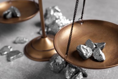 Photo of Vintage scales with silver nuggets on light grey table, closeup