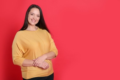 Photo of Beautiful overweight woman with charming smile on red background. Space for text