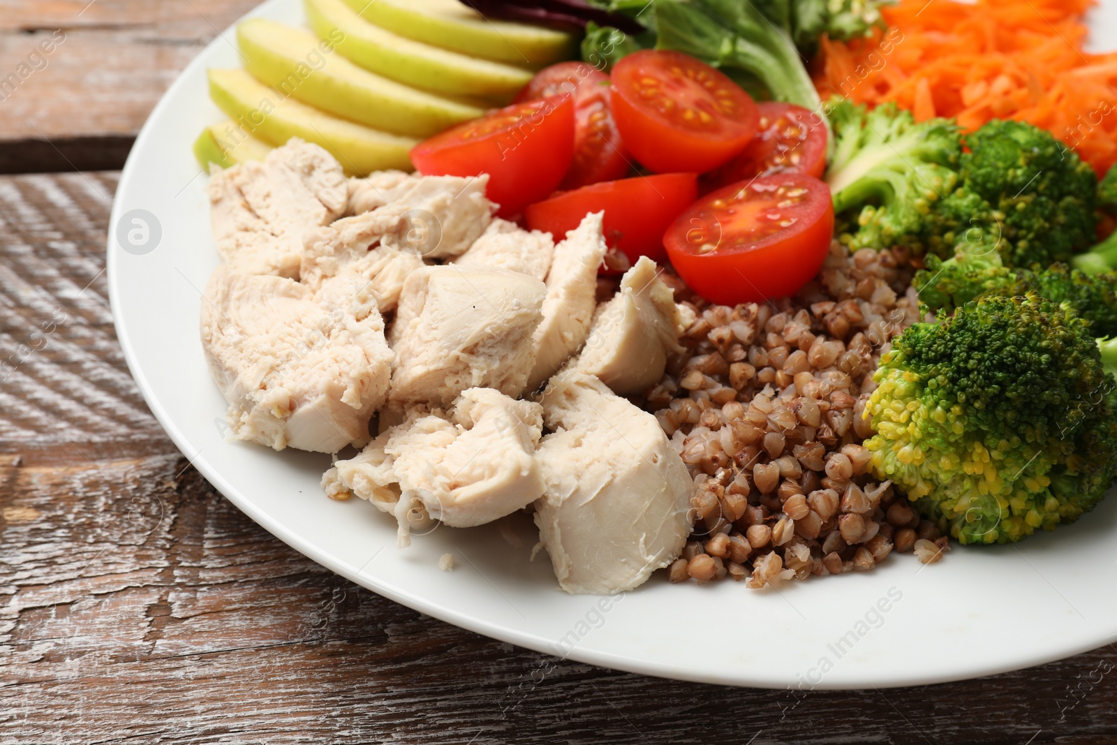 Photo of Balanced diet and healthy foods. Plate with different delicious products on wooden table, closeup