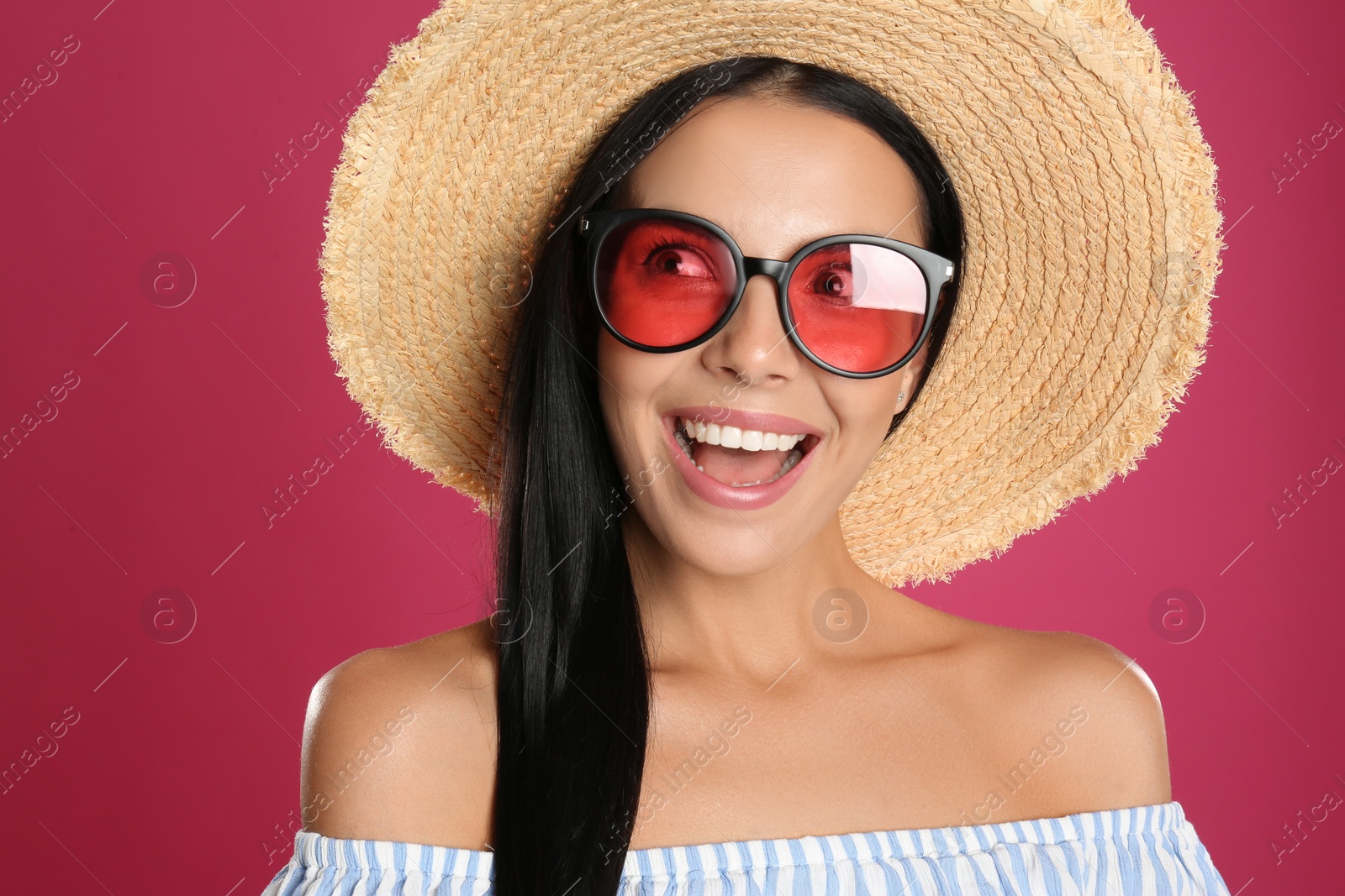 Photo of Beautiful woman wearing sunglasses on pink background, closeup