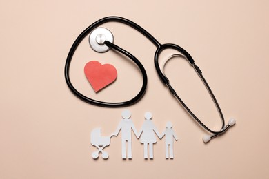Photo of Paper family figures, red heart and stethoscope on beige background, flat lay. Insurance concept