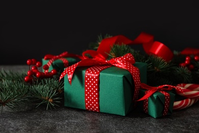 Green Christmas gift boxes with red bows on grey table