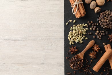 Photo of Different spices on wooden table, top view. Space for text