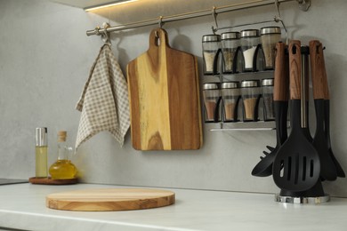 Photo of Wooden cutting boards and other cooking utensils on white countertop in kitchen