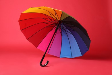 Photo of Stylish open bright umbrella on red background
