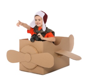 Cute little boy playing with binoculars and cardboard airplane on white background