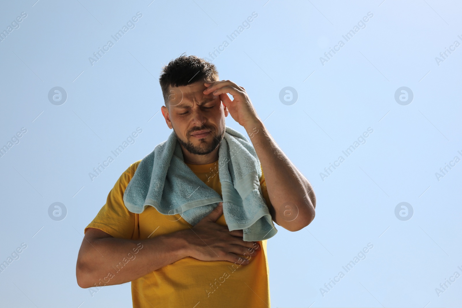 Photo of Man with towel suffering from heat stroke outdoors