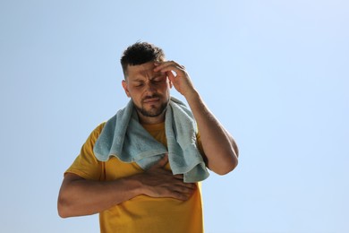 Man with towel suffering from heat stroke outdoors