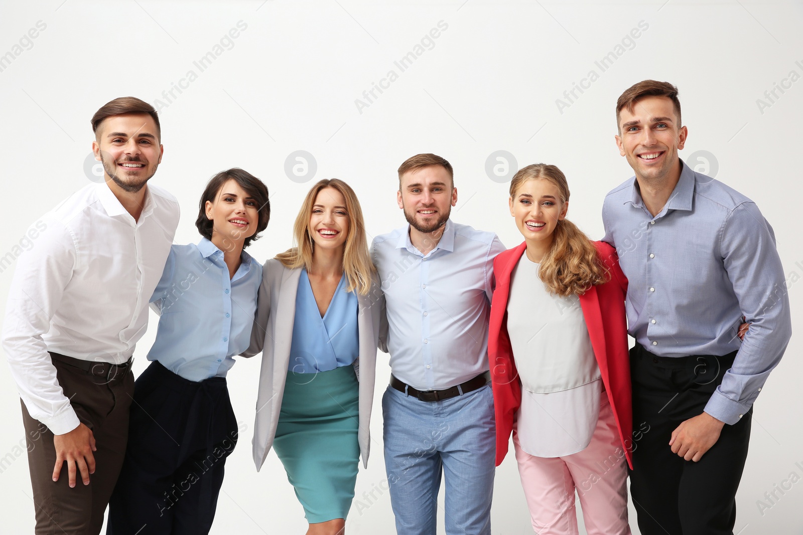 Photo of Group of young people hugging each other on light background. Teamwork concept