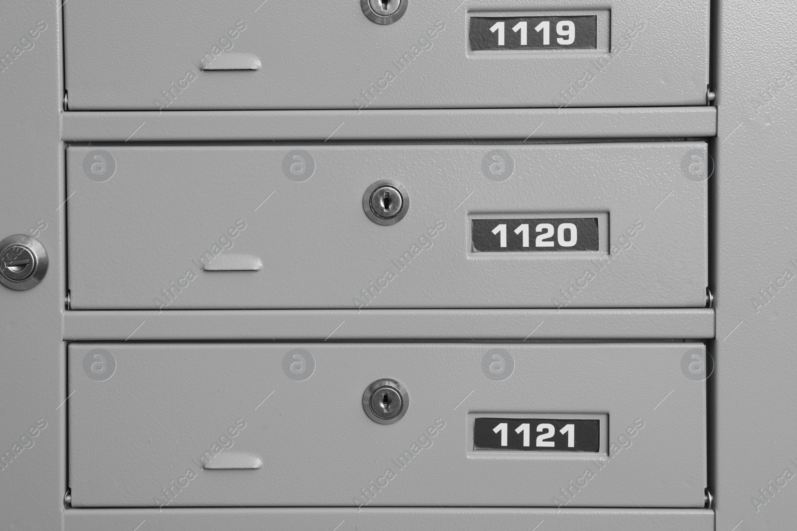 Photo of Closed metal mailboxes with keyholes and sequence numbers indoors