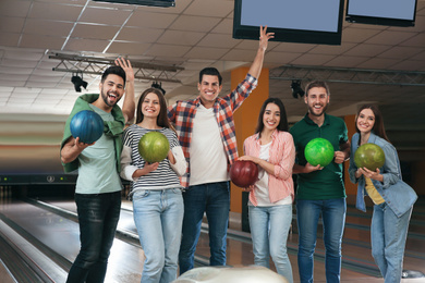 Photo of Group of friends with balls in bowling club