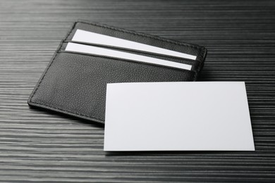 Leather business card holder with blank cards on grey table, closeup