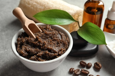 Photo of Bowl of coffee scrub with scoop on table