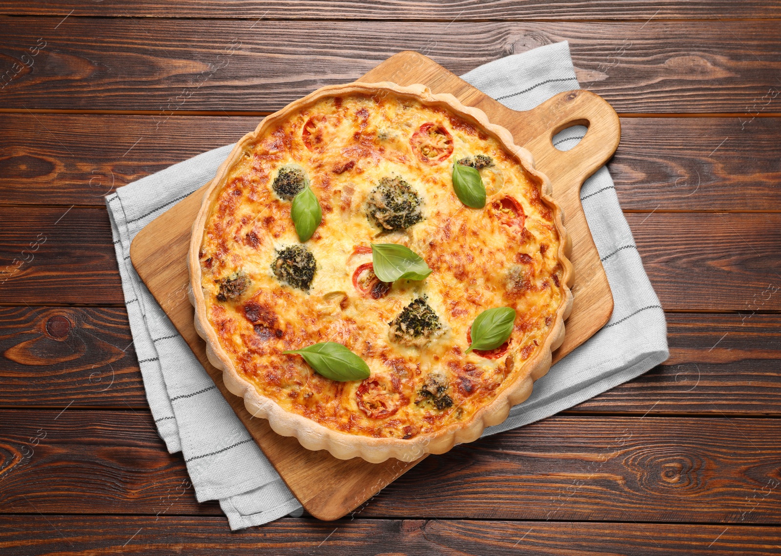 Photo of Delicious homemade vegetable quiche on wooden table, top view